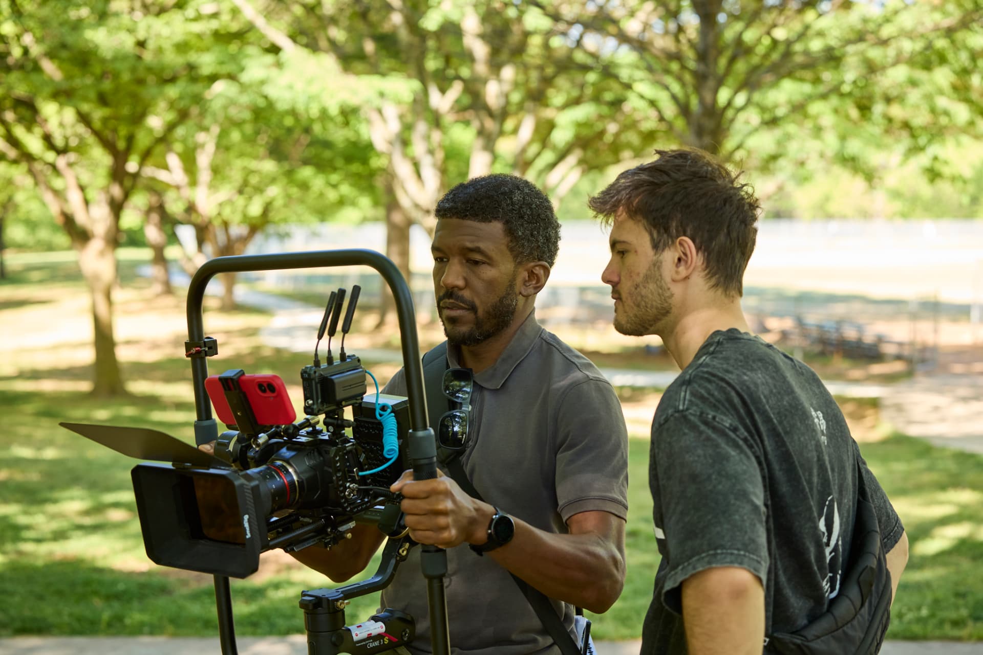 Crew members working the camera rig in the park