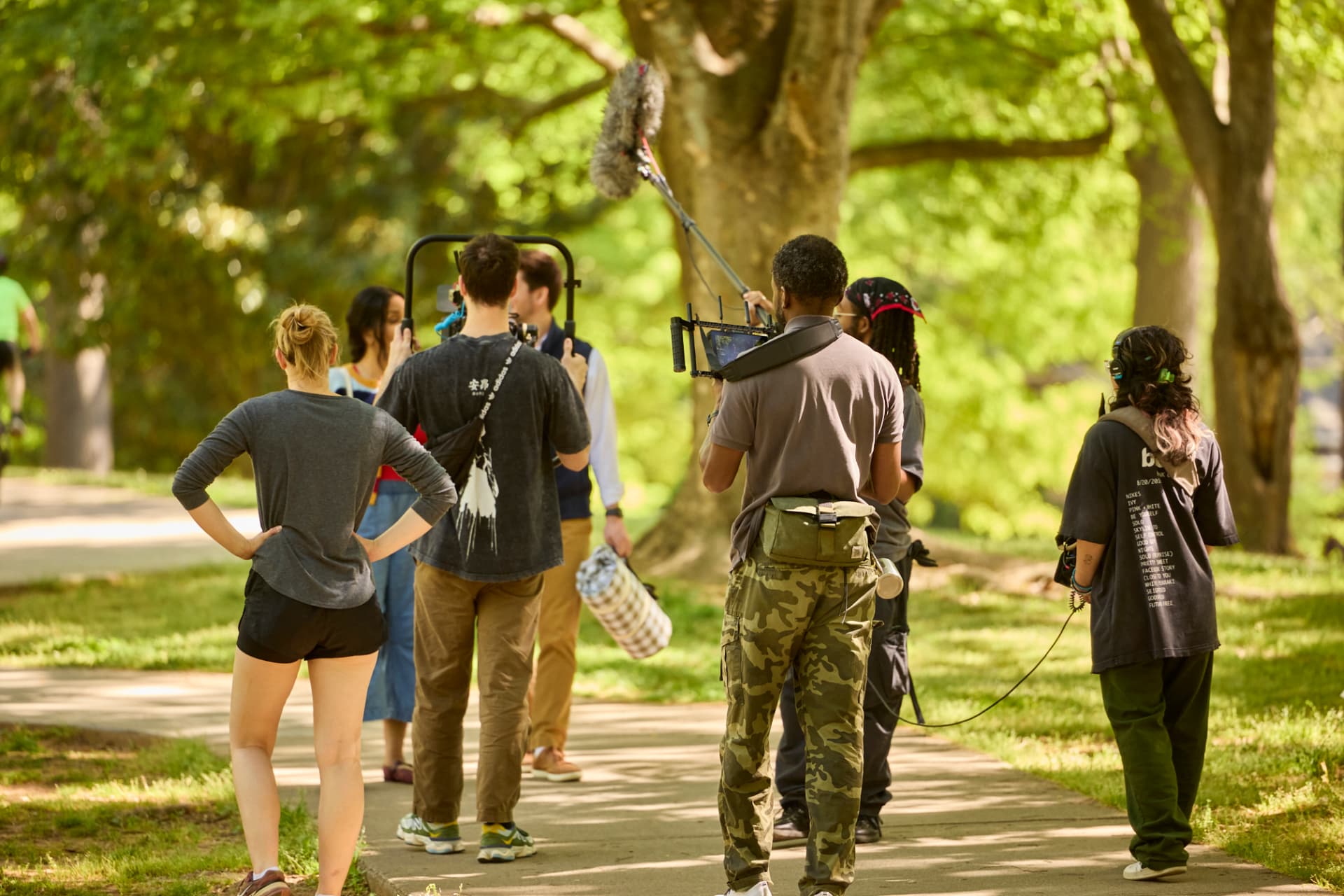 Crew filming a scene with a boom microphone in the park